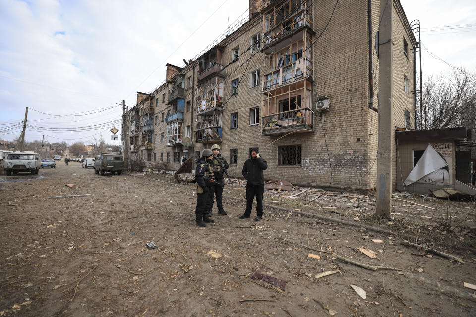 Ukrainian police officers stand in front of a house which was damaged after a Russian attack in Kostiantynivka, Ukraine, Saturday, Jan. 28, 2023. (AP Photo/Andriy Dubchak)