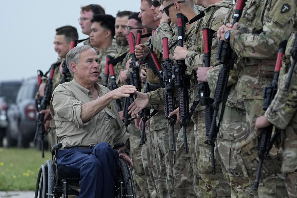 Texas Gov. Greg Abbott, left, shakes hands with members of the Texas National Guard as they prepare to deploy to the Texas-Mexico border in Austin, Texas, Monday, May 8, 2023. The Title 42 policy, a federal rule that has allowed the government to strictly regulate border entries, is set to expire this week. (AP Photo/Eric Gay)