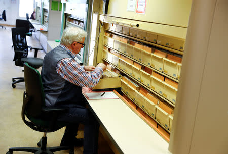 Head of the record archive Rupert Carus works on record cards of the former East German Ministry for State Security (MfS), known as the Stasi, while he poses during a tour at the central archives office in Berlin, Germany, March 12, 2019. Picture taken March 12, 2019. REUTERS/Fabrizio Bensch