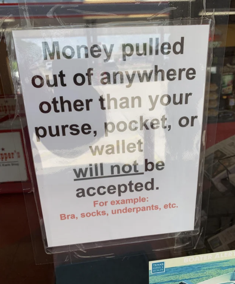 The sign says "money pulled out of anywhere other than your purse, pocket, or wallet will not be accepted; for example: bra, socks, underpants, etc"