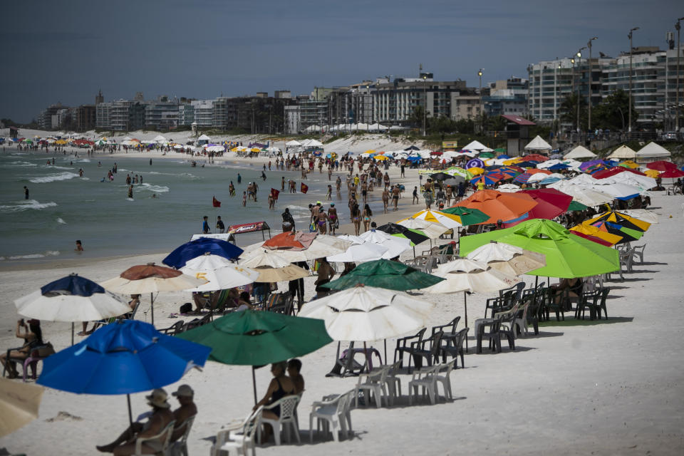 Beachgoers congregate on Fort Beach in Cabo Frio, Brazil, Wednesday, Dec. 15, 2021. G.A.S Consulting & Technology, a cryptocurrency investment firm founded by Glaidson Acacio dos Santos, a former waiter-turned-multimillionaire who is the central figure in what is alleged to be one of Brazil’s biggest-ever pyramid schemes, was based in the beach town dos Santos called home. (AP Photo/Bruna Prado)