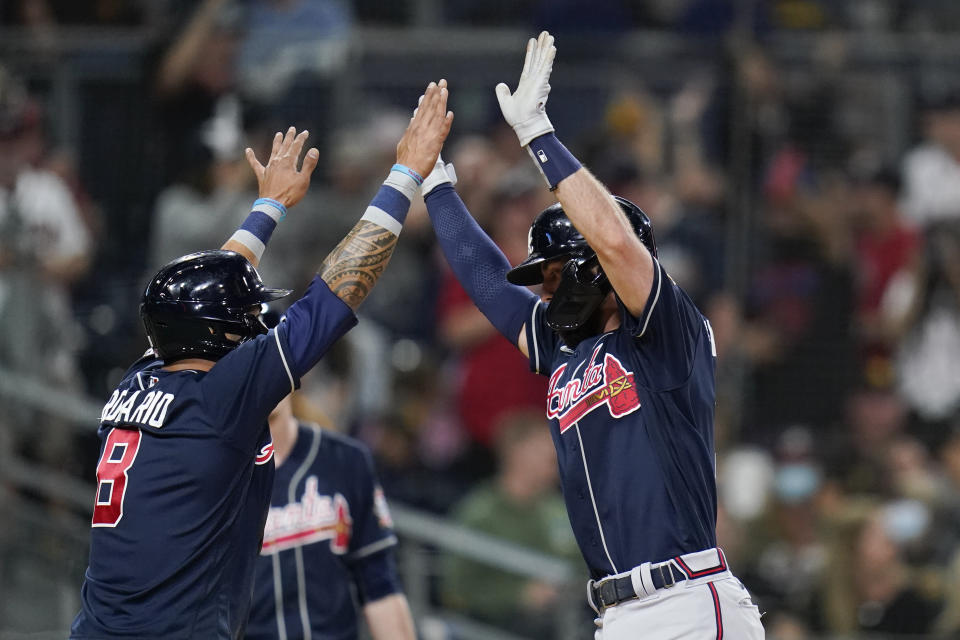 Atlanta Braves' Dansby Swanson, right, reacts with teammate Eddie Rosario after hitting a two-run home run during the second inning of a baseball game against the San Diego Padres, Friday, Sept. 24, 2021, in San Diego. (AP Photo/Gregory Bull)