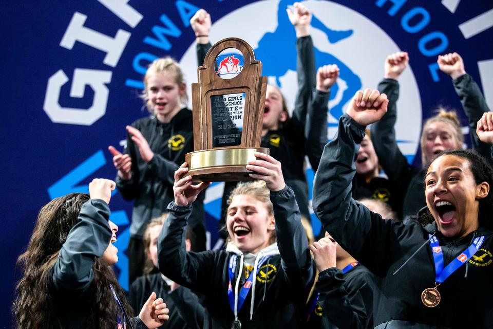 Waverly-Shell Rock wrestlers celebrate after winning the team title in the finals during of the Iowa Wrestling Coaches and Officials Association (IWCOA) girls' state wrestling tournament, Saturday, Jan. 22, 2022, at the Xtream Arena in Coralville, Iowa.