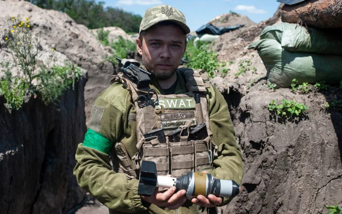 A Ukrainian soldier holds a bomb for a drone in a trench in Chasiv Yar - Ryna Rybakova/AP