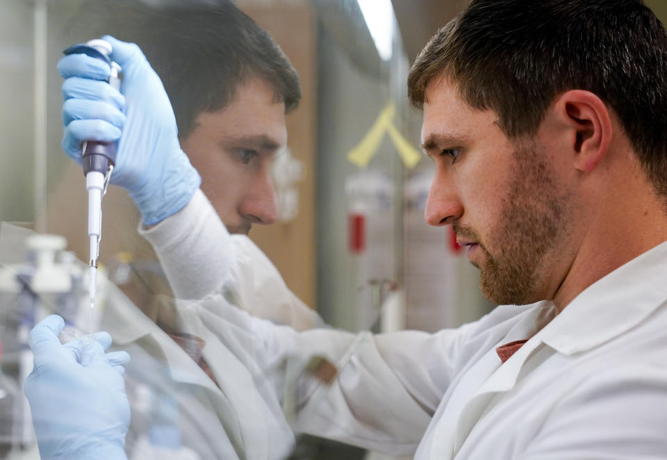 Research scientist Kevin Potts uses ovarian cancer cells to set up an experiment at UW Medicine's Cancer Vaccine Institute Thursday, May 25, 2023, in Seattle. Vaccines under development at UW Medicine are designed to work for many patients, not just a single patient. Tests are underway in early and advanced breast cancer, lung cancer and ovarian cancer. Some results may come as soon as next year. (AP Photo/Lindsey Wasson)