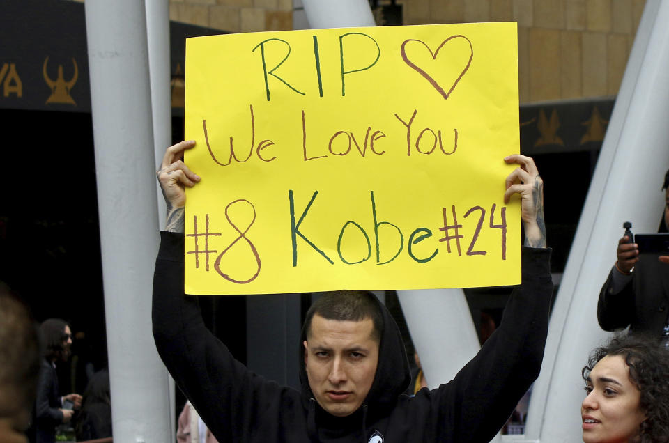 A man holds a sign memorializing Kobe Bryant at the LALive area across from Staples Center, home of the Los Angeles Lakers, after word of the Lakers star's death in a helicopter crash in downtown Los Angeles Sunday, Jan. 26, 2020. (AP Photo/Matt Hartman)