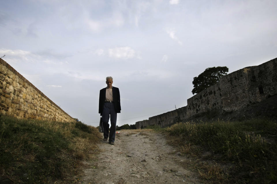 In this photo taken Thursday, July 11, 2013, a man walks past the Kalemegdan fortress walls in Belgrade, Serbia. Belgrade today is known for nightlife, clubbing and a fun-loving lifestyle, but its past is scarred by war. Over centuries it was conquered and demolished dozens of times, standing at the historic crossroads between two mighty empires, Turkish to the east and Austro-Hungarian to the west. Even at the very end of the 20th century, the city was bombed by NATO. But Belgrade’s citizens like to compare their city to the mythical phoenix bird that always rises from the ashes. (AP Photo/ Marko Drobnjakovic)