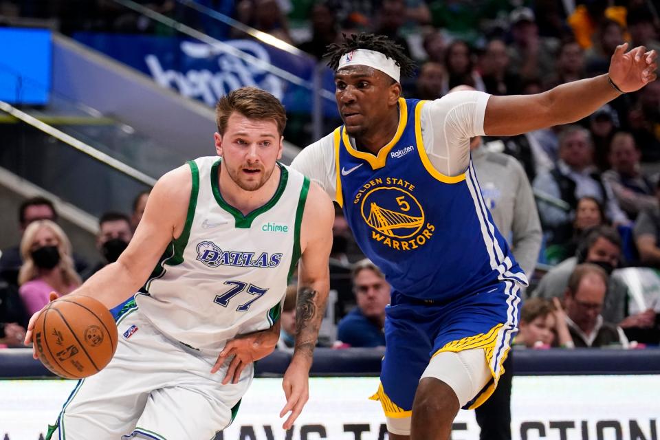 Dallas Mavericks guard Luka Doncic works to get past Golden State Warriors center Kevon Looney (5) in the first half of an NBA basketball game in Dallas, Thursday, March, 3, 2022. (AP Photo/Tony Gutierrez)