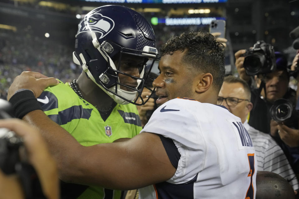 Seattle Seahawks quarterback Geno Smith, left, talks with Denver Broncos quarterback Russell Wilson, right, after an NFL football game, Monday, Sept. 12, 2022, in Seattle. The Seahawks won 17-16. (AP Photo/Stephen Brashear)