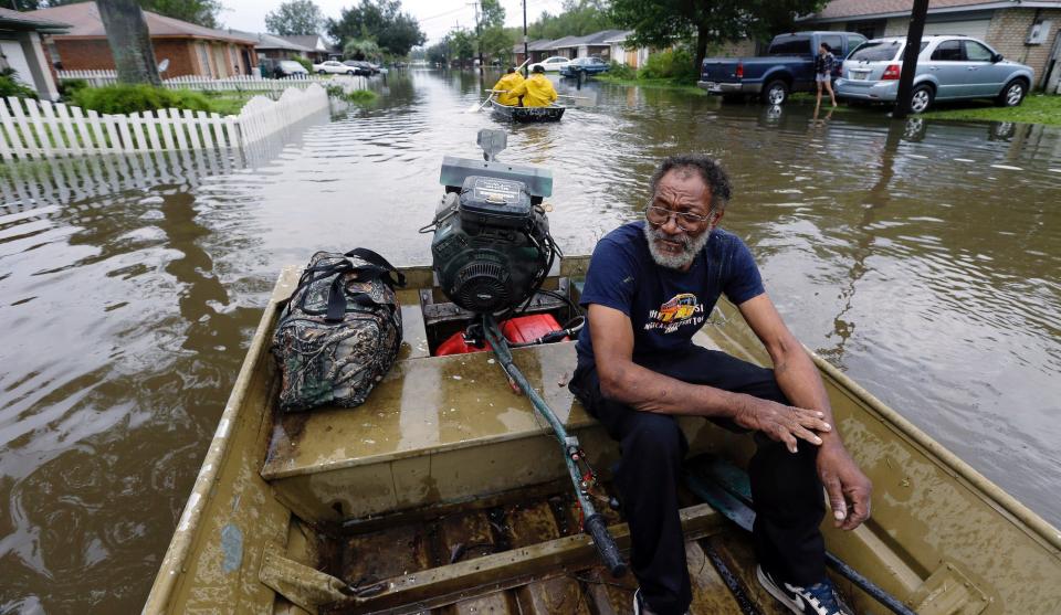 Milton is taken by boat from a flooded neighborhood, Thursday, Aug. 30, 2012, in Reserve, La.