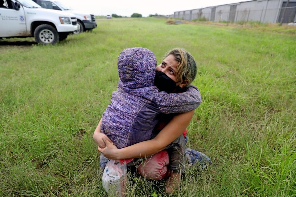 A woman clutches her child and cries.