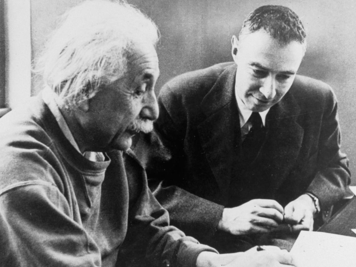 J. Robert Oppenheimer working with Albert Einstein.