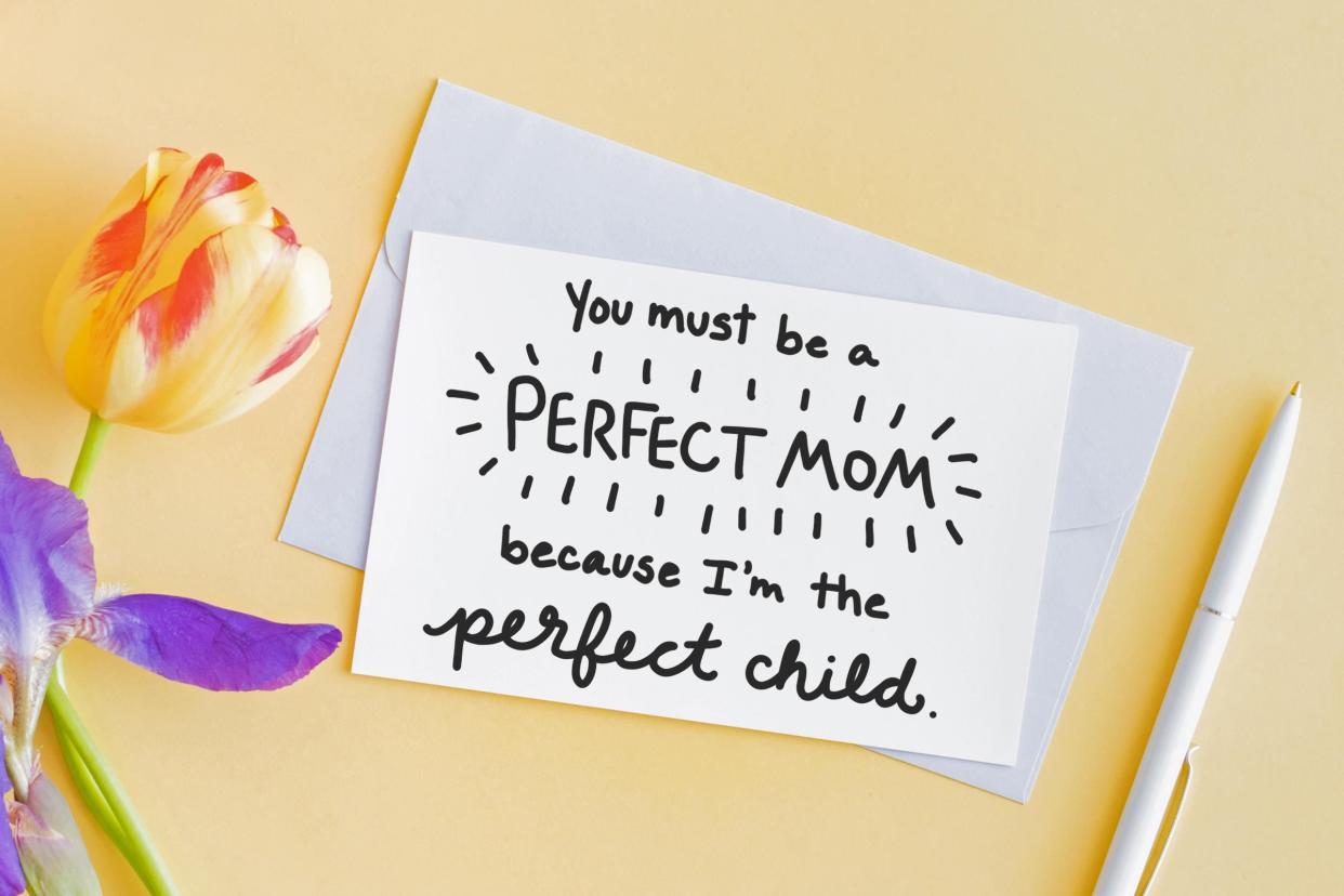 card, colorful tulip, and pen on orange background. card reads, "You must be a perfect mom because I'm the perfect child"