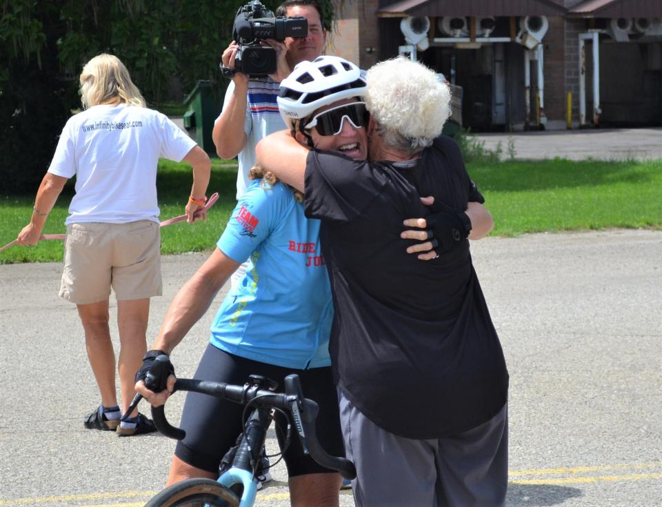 Battle Creek's Nicole Jaeger gets a hug from her mom Donna Jaeger at a reception at the Urbandale  Plaza after riding into town on Tuesday as she nears the end of her 2,000-plus mile 'Ride For Poppy' that has seen her ride her bike from Oregon to Michigan in an effort to raise money for cancer research in honor of her late father.