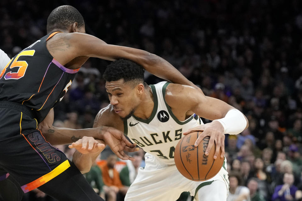 Milwaukee Bucks forward Giannis Antetokounmpo, right, gets past Phoenix Suns forward Kevin Durant during the first half of an NBA basketball game Tuesday, Feb. 6, 2024, in Phoenix. (AP Photo/Ross D. Franklin)