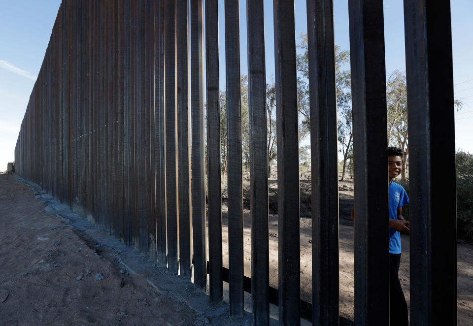 <p>A boy looks through the first section of a newly-constructed structure along the border separating Mexicali, Mexico, right, and Calexico, Calif., March 5, 2018. (Photo: Gregory Bull/AP) </p>