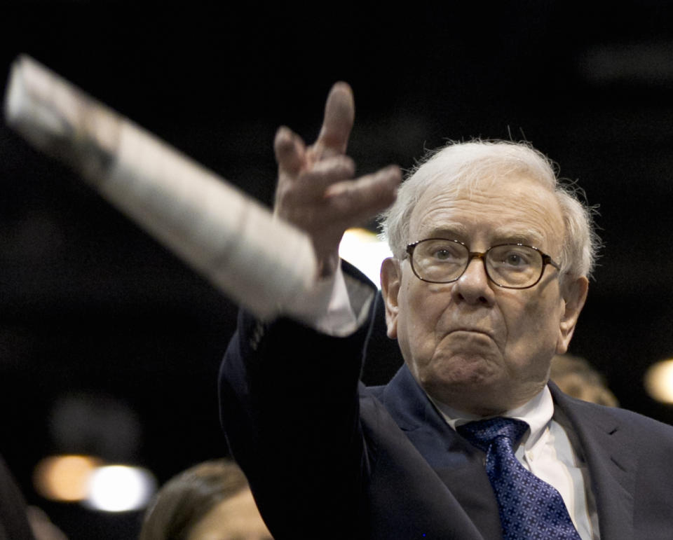 Warren Buffett, chairman and CEO of Berkshire Hathaway tosses a newspaper during a newspaper tossing competition in Omaha, Neb., Saturday, May 5, 2012. Berkshire Hathaway is holding it's annual shareholders meeting this weekend. (AP Photo/Nati Harnik)