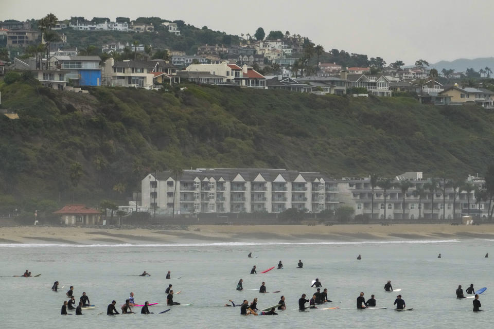 Surfers wait for waves at Doheny State Park Beach off Dana Point, Calif., Sunday, Aug. 20, 2023. Tropical Storm Hilary swirled northward Sunday just off the coast of Mexico's Baja California peninsula, no longer a hurricane but still carrying so much rain that forecasters said "catastrophic and life-threatening" flooding is likely across a broad region of the southwestern U.S. (AP Photo/Damian Dovarganes)