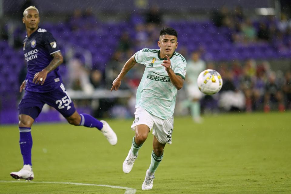 FILE - Atlanta United's Thiago Almada, right, gets position on a pass in front of Orlando City's Antonio Carlos (25) during the first half of an MLS soccer match Wednesday, Sept. 14, 2022, in Orlando, Fla. The 21-year-old will step into a larger role this season for Atlanta United following the departure of Martinez to Miami. Almada appeared in 29 games and had six goals and seven assists last season. Atlanta will be hoping that Almada can quickly develop a relationship with new forward Giorgos Giakoumakis, who just arrived from Celtic. (AP Photo/John Raoux, File)