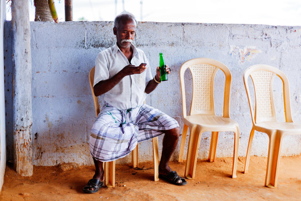 A man chills with a drink and lungi in Tamil Nadu, India. (Photo: Himanshu Khagta via Getty Images)