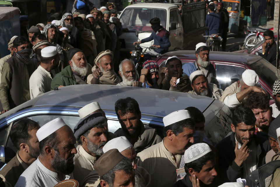 People wait in long queue to buy sack of wheat-flour on subsidize rate at a sale point, in Peshawar, Pakistan, Tuesday, Feb. 14, 2023. Cash-strapped Pakistan nearly doubled natural gas taxes Tuesday in an effort to comply with a long-stalled financial bailout, raising concerns about the hardship that could be passed on to consumers in the impoverished south Asian country. Pakistan's move came as the country struggles with instability stemming from an economic crisis. (AP Photo/Muhammad Sajjad)