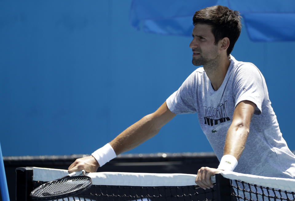 Serbia's Novak Djokovic rests on the net during a practice session at the Australian Open tennis championships in Melbourne, Australia, Sunday, Jan. 13, 2019. (AP Photo/Mark Schiefelbein)