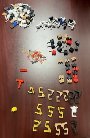 A collection of 3D-printed machine gun conversion devices and other gun parts confiscated by the Evansville Police Department and a joint task force during a Jan. 31, 2024, operation in Evansville.