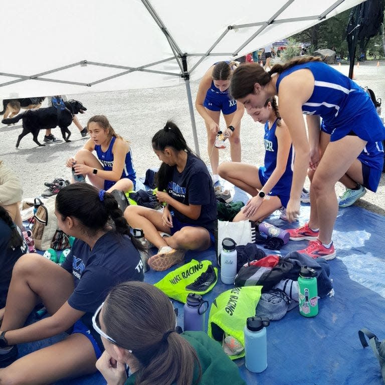 Xavier College Prep girls take to cover as they await their races.