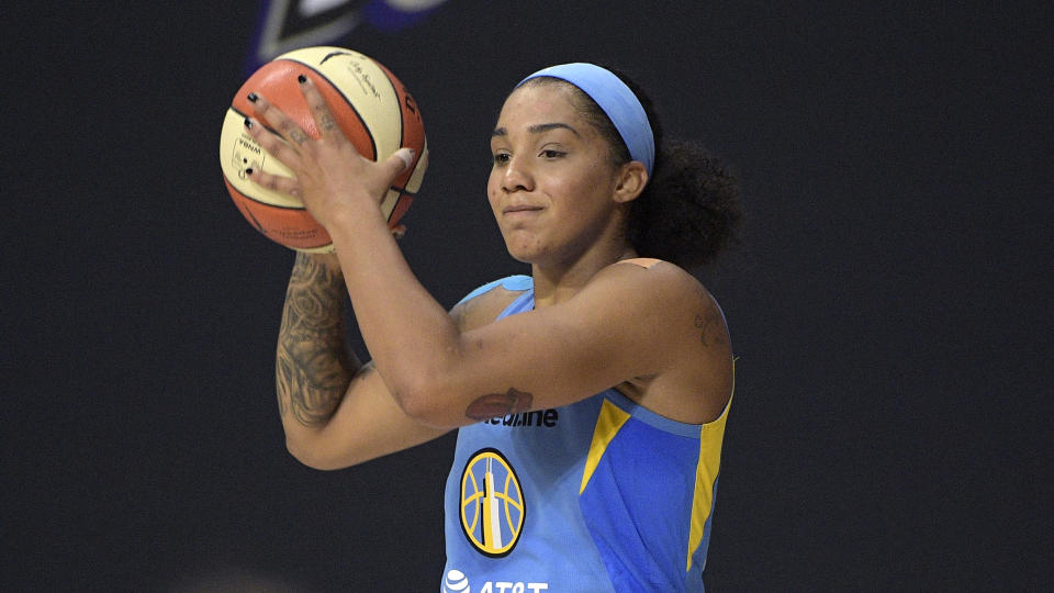 Gabby Williams sets up a play during a Chicago Sky game. She is holding the ball in both hands near her head and looking forward.