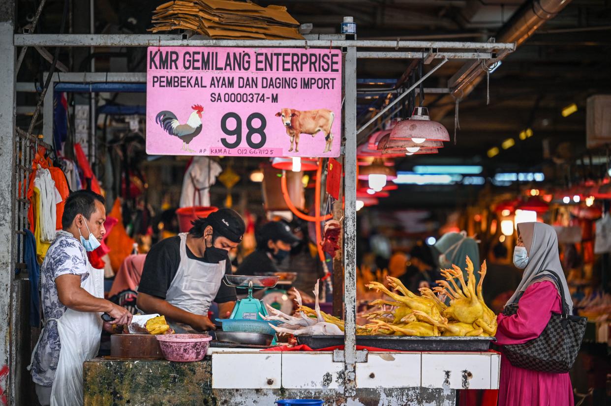 A customer waits to buy chicken meat at a wet market in Kuala Lumpur on September 1, 2021. (Photo by Mohd RASFAN / AFP) (Photo by MOHD RASFAN/AFP via Getty Images)