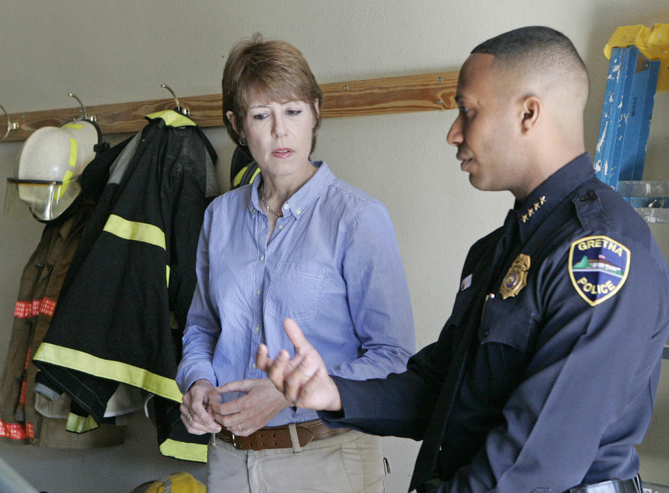 U.S. House candidate Gwen Graham listens to Police Chief and public safety director Carlos De La Cruz as he explains the workings of his department on Thursday, April 10, 2014, in Gretna, Fla. On campaign stops Graham had something going for her: her last name. Voter after voter recounted fond memories of her father, Bob, who towered over Florida politics for more than a quarter-century as governor and U.S. senator. (AP Photo/Steve Cannon)