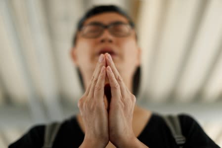 A man prays as people gather near the Legislative Council building to wait for a government announcement regarding the proposed extradition bill, in Hong Kong,