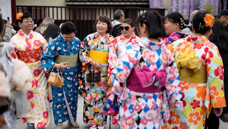 Foreign visitors in traditional Japanese "kimono" stand along a shopping street at the Asakusa district, Thursday, March 28, 2024, in Tokyo.