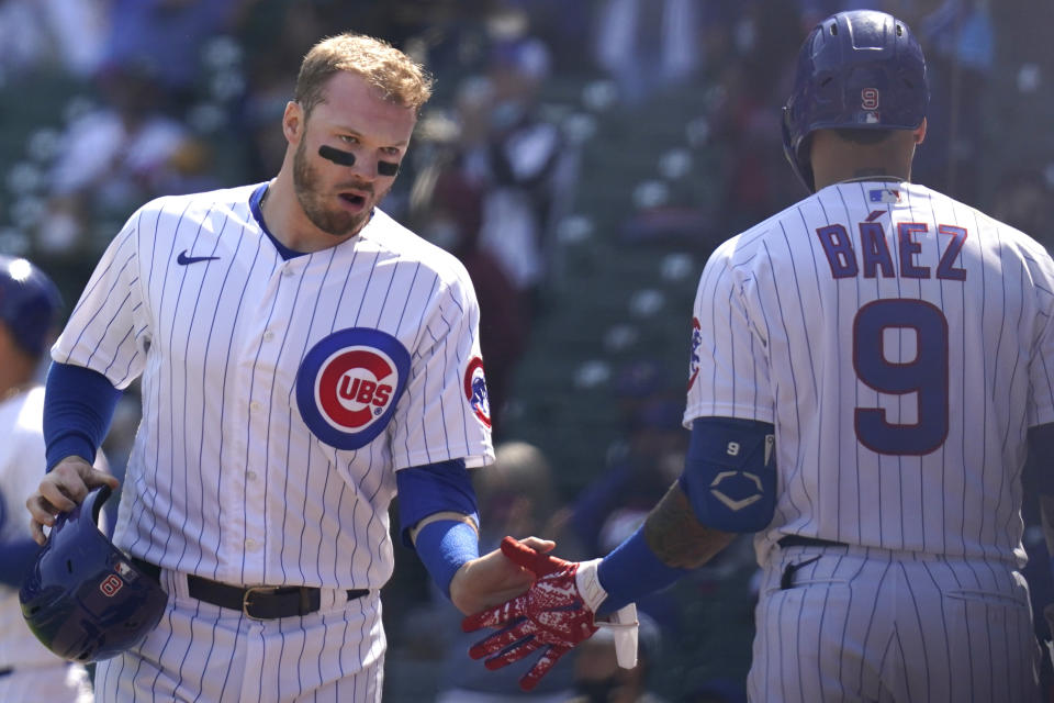 Chicago Cubs' Ian Happ, left, celebrates with teammate Javier Baez after scoring on a single during the first inning of a baseball game against the Pittsburgh Pirates in Chicago, Sunday, April 4, 2021. (AP Photo/Nam Y. Huh)