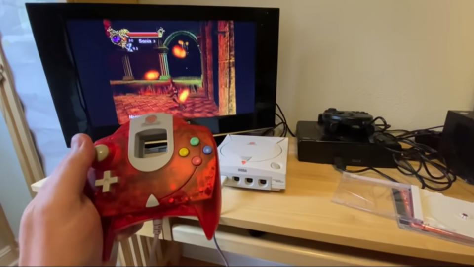 a hand holds a Sega Dreamcast remote while playing Castlevania Resurrection