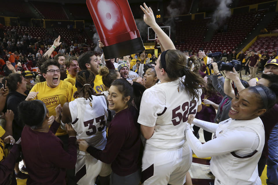 Arizona State players and students celebrate their upset win over Oregon State at the end of an NCAA college basketball game Sunday, Jan. 12, 2020, in Tempe, Ariz. (AP Photo/Darryl Webb)