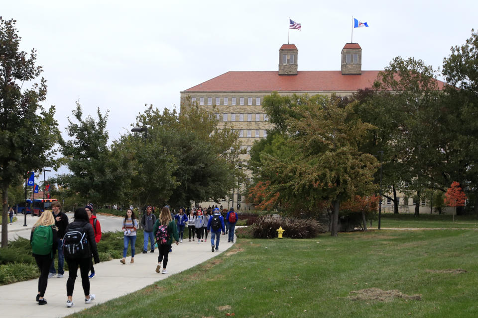 FILE - Students walks in front of Fraser Hall on the University of Kansas campus in Lawrence, Kan., Thursday, Oct. 24, 2019. The northeast Kansas town of Lawrence is moved under a redistricting plan from Republican legislators into a district with central and western Kansas. Lawrence is known for its liberal politics, and it would go into a district where former President Donald Trump received more than 70% of the vote in 2020. (AP Photo/Orlin Wagner, File)