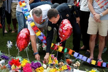 Orlando mayor Buddy Dyer (L) and Chief of Police John Mina lay flowers at a memorial service the day after a mass shooting at the Pulse gay nightclub in Orlando, Florida, U.S. June 13, 2016. REUTERS/Carlo Allegri