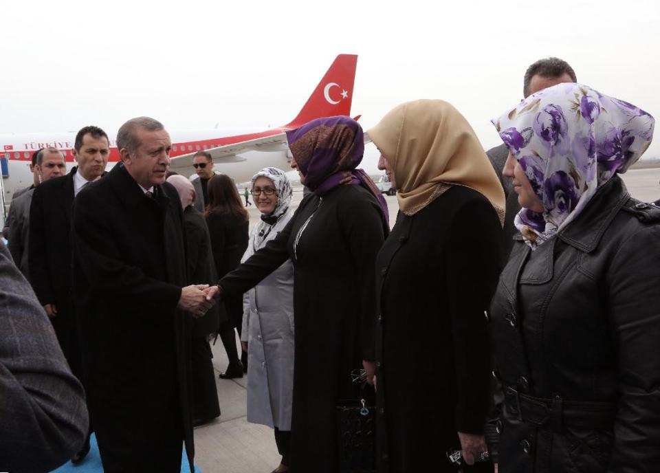 FILE - In this March 6, 2014 file photo, Turkish Prime Minister Recep Tayyip Erdogan is welcomed by his party members at the airport in Elazig, Turkey. Erdogan has been ensnared in a corruption scandal that has toppled four Cabinet ministers. He has provoked outrage at home and abroad with an attempt to block Twitter and YouTube. His incessant us-against-them rhetoric and conspiracy theories have alienated allies. Meanwhile, the Turkish Lira has fallen, interest rates are up and the Turkish economy has fallen off a cliff. It all might be enough to oust any leader. But as Turks prepare to vote in local elections Sunday, it’s all about Erdogan.(AP Photo/Burhan Ozbilici, File)