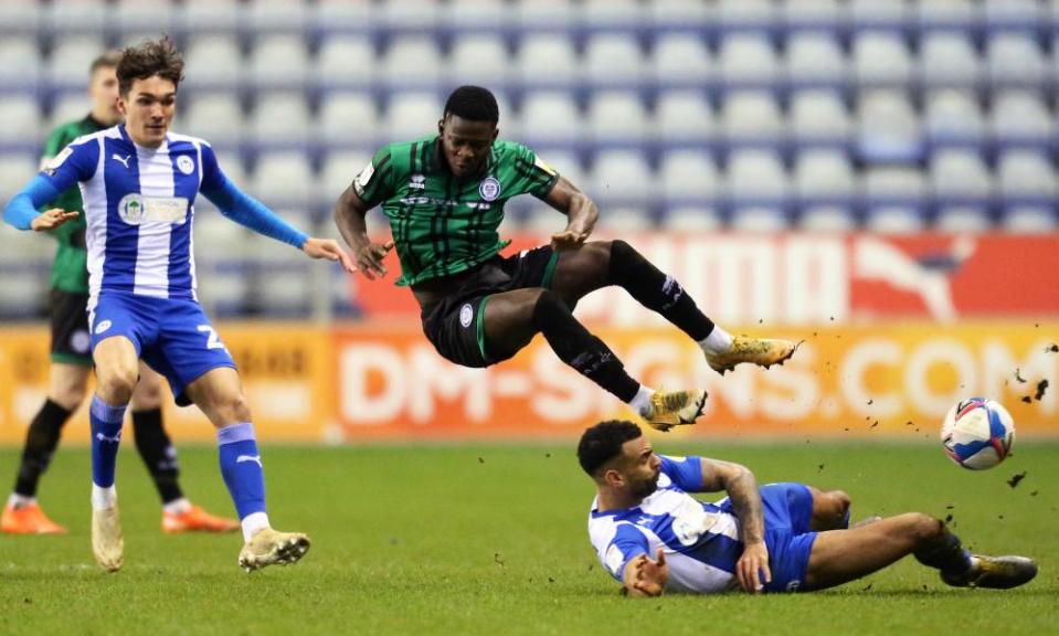 Kwadwo Baah feels the force of a tackle by Wigan’s Curtis Tilt.