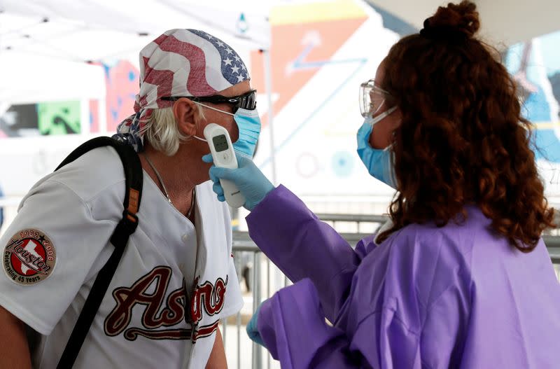 A supporter wearing a face mask has his temperature checked outside the venue for U.S. President Donald Trump's rally in Tulsa