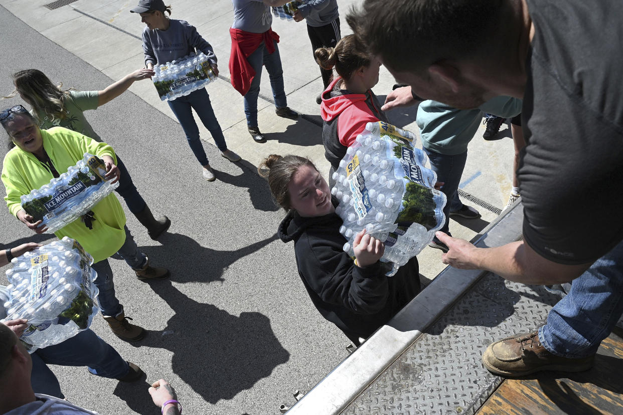 Volunteers help unload water at Sullivan Community Center for the residents and rescue personnel affected by Friday's tornado in Sullivan, Ind., Sunday, April 2, 2023. (Joseph C. Garza/The Tribune-Star via AP)