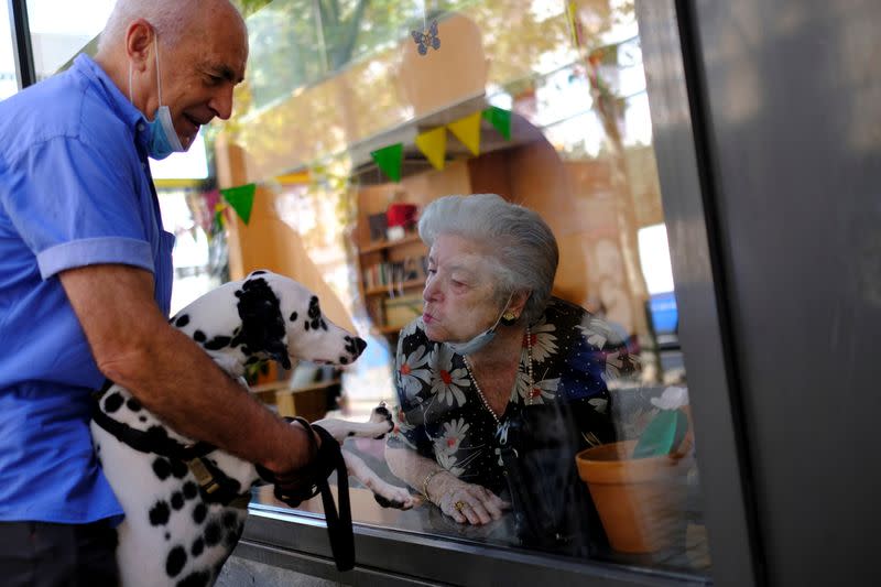 Elderly people get love through nursing home glass front as COVID-19 surges