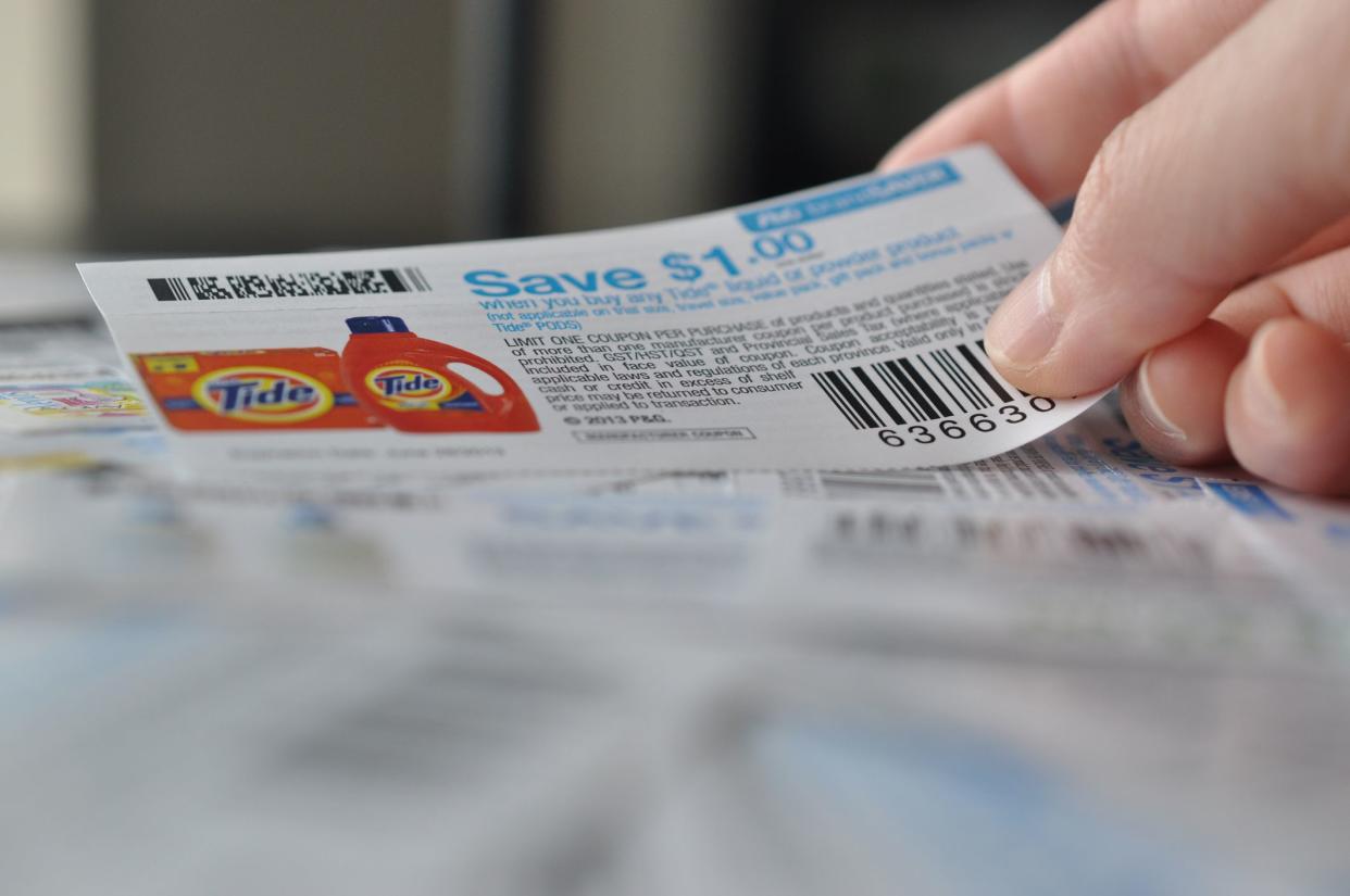 Coquitlam, BC, Canada - May 8, 2014 : Holding coupon for saving item. All coupons for Canadian store, they are issued by manufacturers of consumer packaged goods or by retailers in Canada.