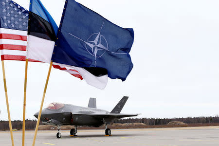 U.S., Estonia's and NATO flags flutter next to the U.S. Air Force F-35A Lightning II fighter in Amari air base, Estonia, April 25, 2017. REUTERS/Ints Kalnins