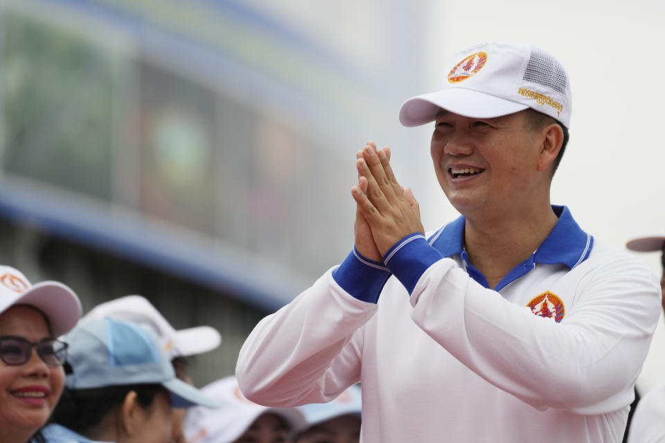 Hun Manet, right, a son of Cambodia Prime Minister Hun Sen, greets supporters before leading a procession to mark the end of an election campaign of Cambodian People's Party, in Phnom Penh, Cambodia, Friday, July 21, 2023. Hun Sen says he is ready to hand the premiership to his oldest son, Hun Manet, who heads the country’s army. (AP Photo/Heng Sinith)