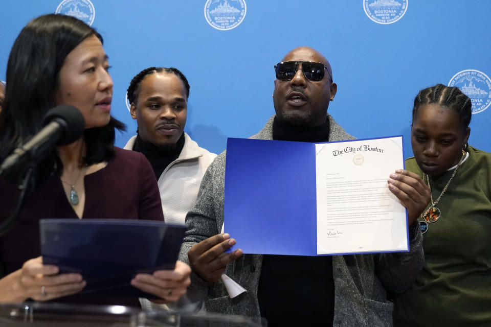 Joseph Bennett, center right, nephew of Willie Bennett, who was wrongly accused in the 1989 death of Carol Stuart, accepts a formal apology on behalf of Willie Bennett, not shown, by Boston Mayor Michelle Wu, left, during a news conference, Wednesday, Dec. 20, 2023, in Boston. Wu issued a formal apology to Alan Swanson and Willie Bennett Wednesday for their wrongful arrests following the 1989 death of Carol Stuart, whose husband, Charles Stuart, had orchestrated her murder. (AP Photo/Steven Senne)