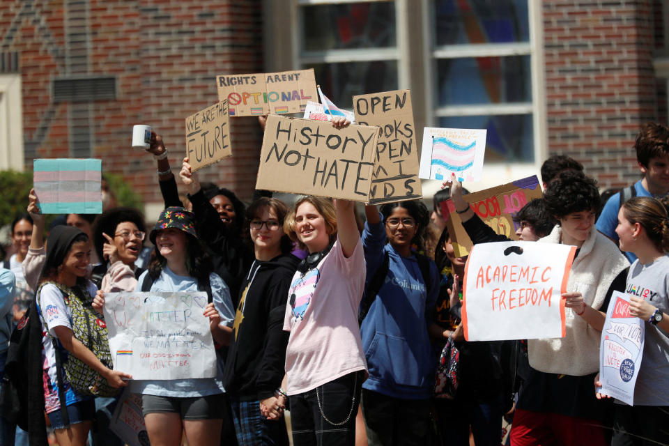 Students holds signs that read, 