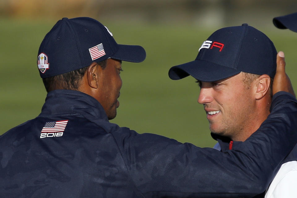 Justin Thomas of the US, right, is congratulated by Tiger Woods after winning his foursome match with his teammate Jordan Spieth on the second day of the 2018 Ryder Cup at Le Golf National in Saint Quentin-en-Yvelines, outside Paris, France, Saturday, Sept. 29, 2018. (AP Photo/Francois Mori)