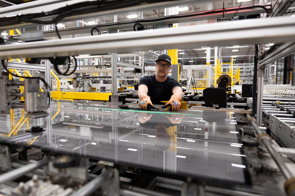 A worker applies tape to a solar panel at First Solar in Perrysburg, Ohio, July 8, 2022. REUTERS/Megan Jelinger